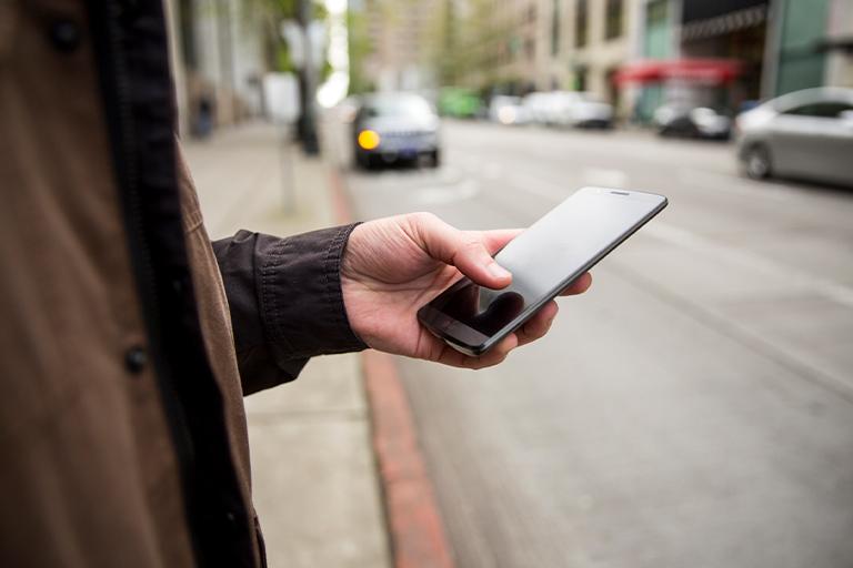 mężczyzna trzymający telefon komórkowy w dłoni